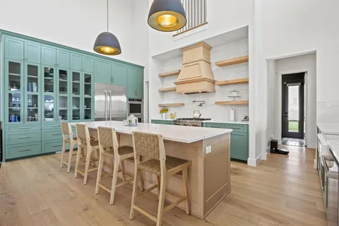 a kitchen with a dining table chairs and view of living room