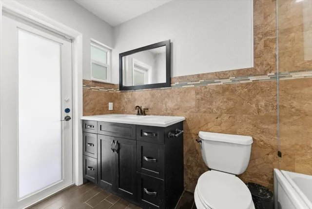 a bathroom with a toilet sink and mirror