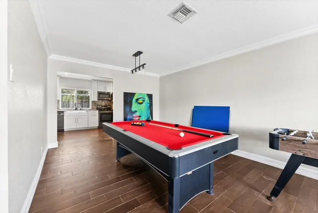 a room with pool table and windows