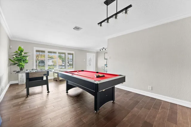 a room with furniture pool table and wooden floor