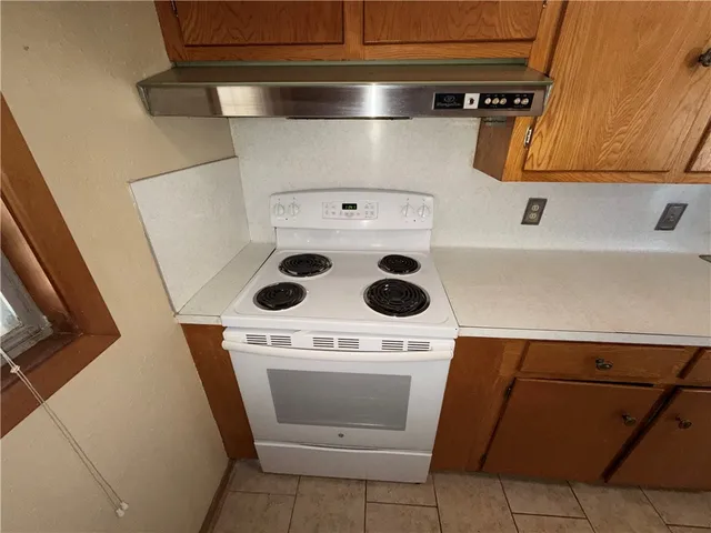 a view of an empty room and chandelier fan