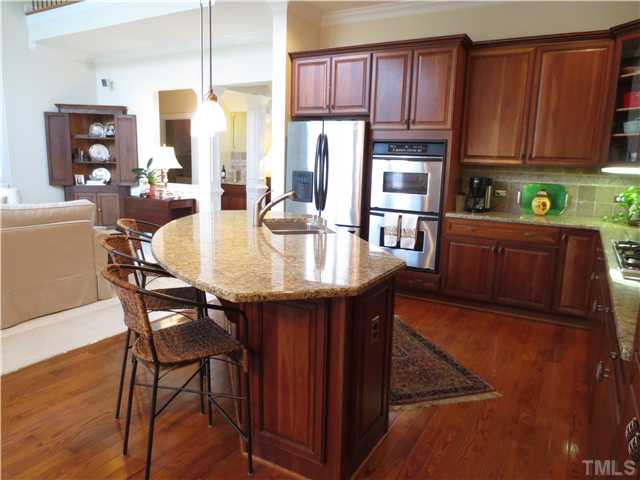 2324 Clayette Court Raleigh, NC 27612 - Photo 8 of 25 a kitchen with stainless steel appliances granite countertop wooden table chairs cabinets and a sink