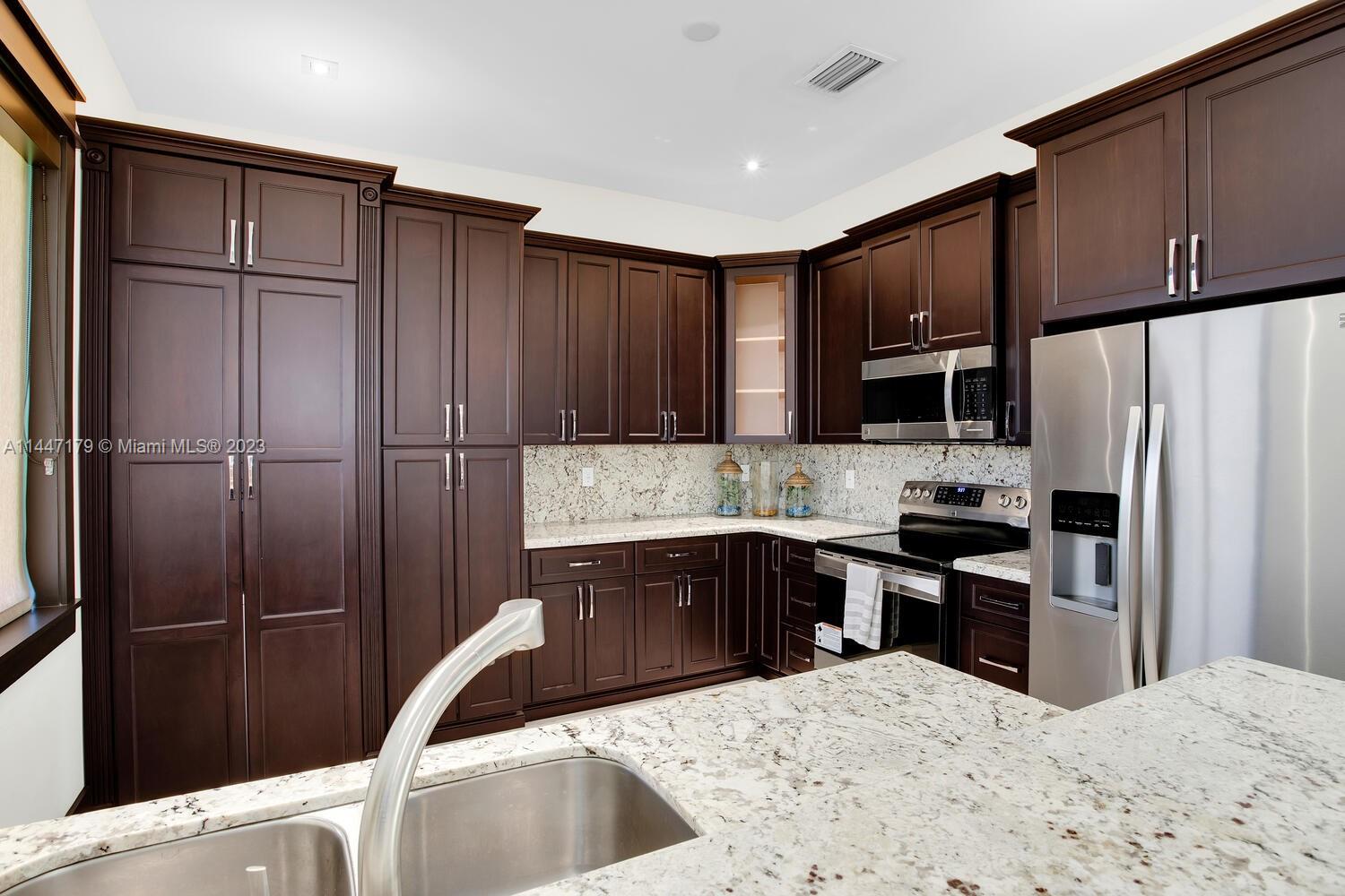 11880 Southwest 47th Street Miami, FL 33175 - Photo 39 of 61 a kitchen with granite countertop a refrigerator and a sink