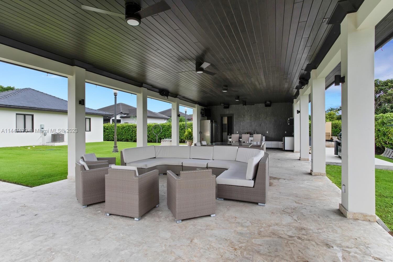 11880 Southwest 47th Street Miami, FL 33175 - Photo 45 of 61 a view of a patio with couches chairs potted plants and a big yard