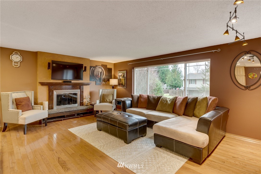 519 213th Place Southwest Bothell, WA 98021 - Photo 3 of 34 a living room with furniture a fireplace and a flat screen tv