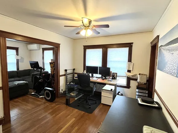 a view of a livingroom with hardwood floor and a workspace