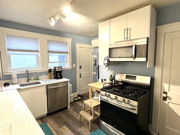 a kitchen with a stove a sink and a microwave