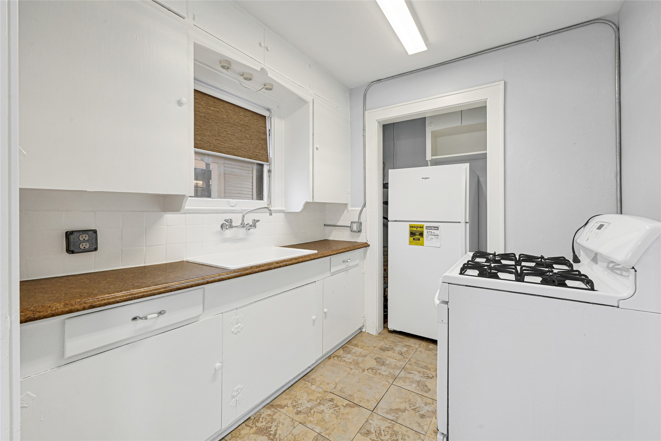 1707 Sidney Street Houston, TX 77023 - Photo 4 of 6 a kitchen with a sink stove and refrigerator