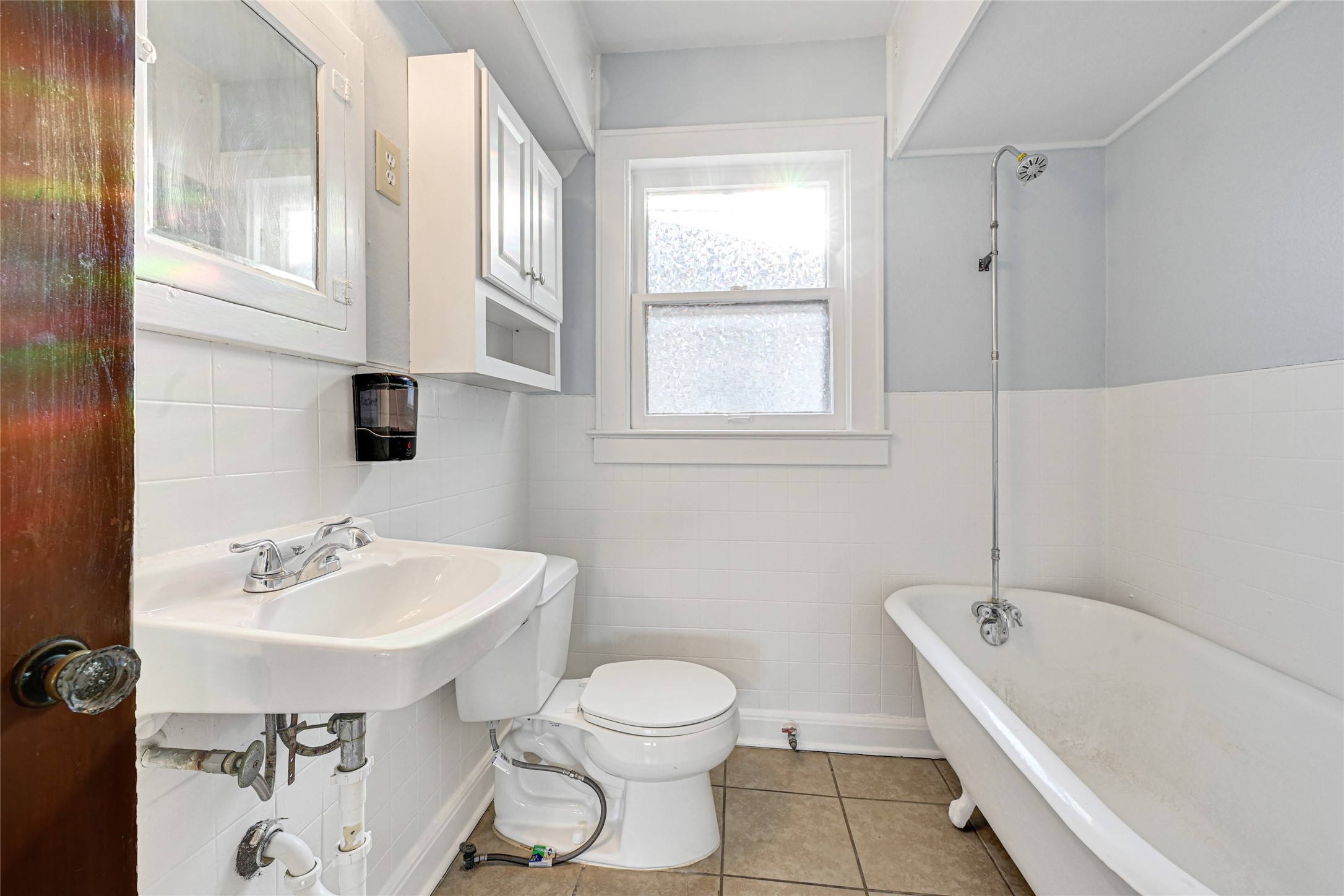 1707 Sidney Street Houston, TX 77023 - Photo 5 of 6 a bathroom with a sink a toilet and bathtub