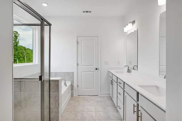 a bathroom with double vanity sink and a mirror
