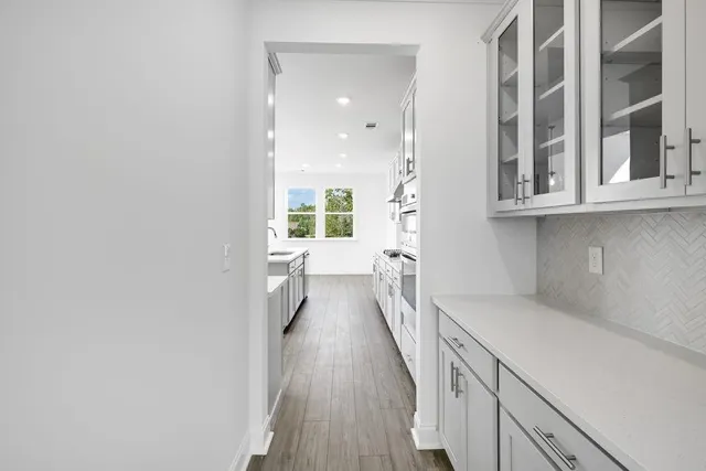 a view of kitchen with kitchen island white cabinetry and stainless steel appliances