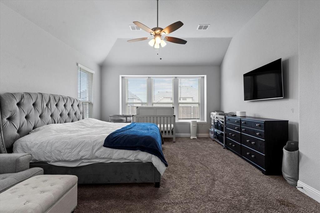 620 Shadow Trail Frisco, TX 75033 - Photo 16 of 36 Spacious bedroom featuring vaulted ceilings, a ceiling fan with integrated lighting, and multiple windows with blinds