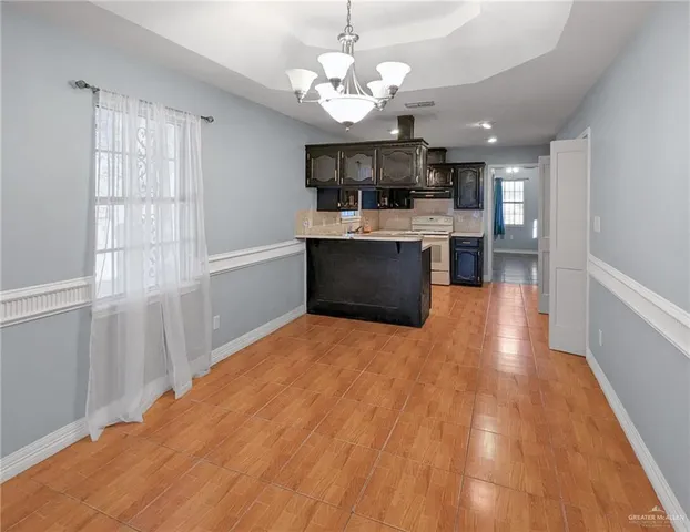 a view of kitchen with stainless steel appliances granite countertop cabinets and window