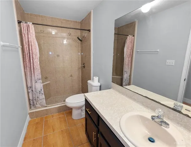 a view of an empty room with closet and windows