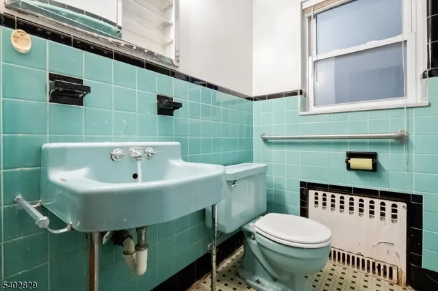 a bathroom with a sink a toilet and a mirror