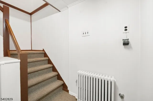 a view of staircase with white walls and a window