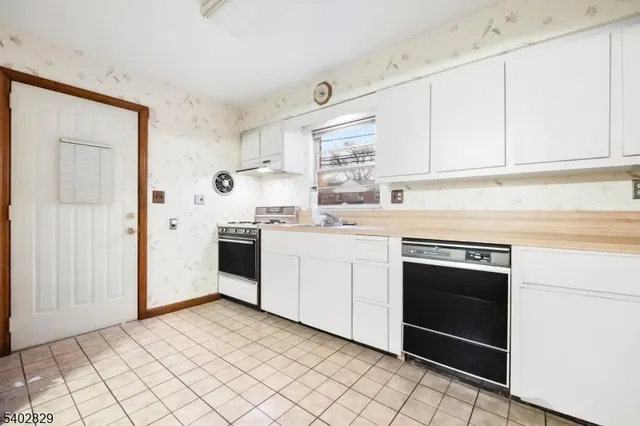 a kitchen with a stove sink and cabinets