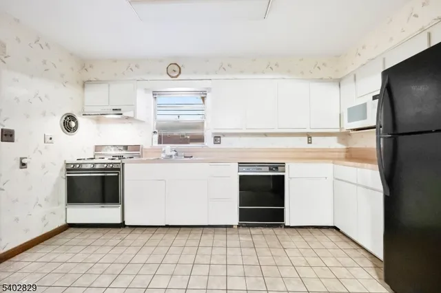 a kitchen with a stove top oven and refrigerator