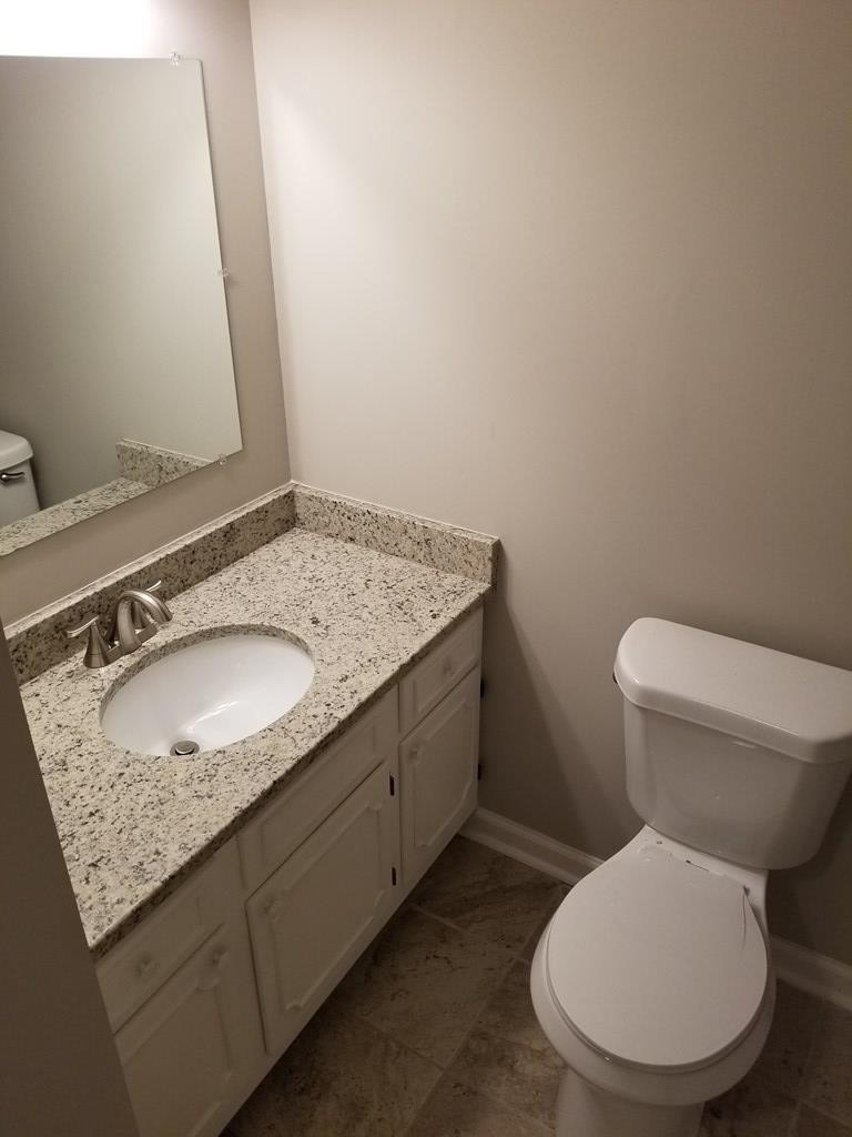 10089 County Line Road Midland, GA 31820 - Photo 17 of 27 a bathroom with a granite countertop toilet sink and mirror