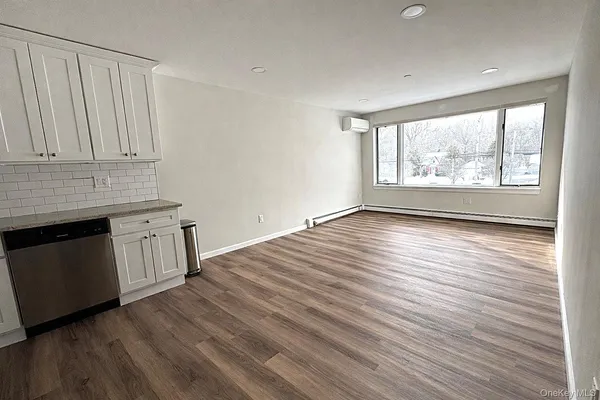 an empty room with wooden floor and a window
