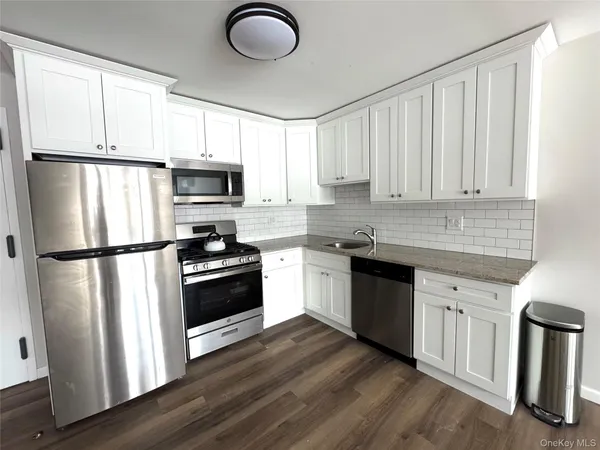 a kitchen with a refrigerator sink and white cabinets