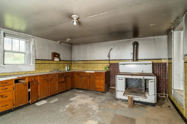 a kitchen with a sink a stove and chairs