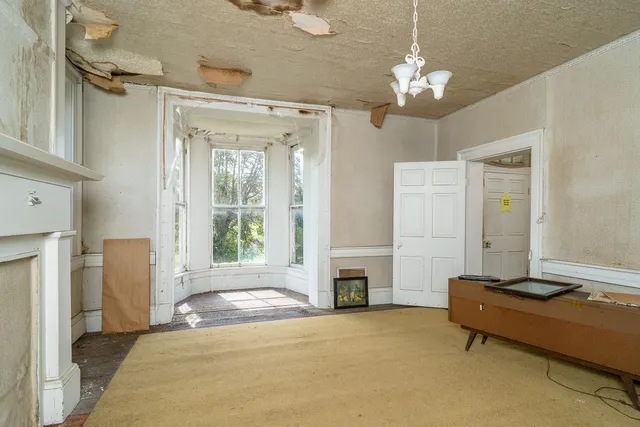 a view of a room with a piano and wooden floor