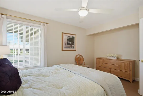 a bedroom with a bed a chair and a two plant