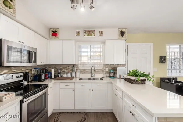 a kitchen with stainless steel appliances granite countertop a sink stove and cabinets