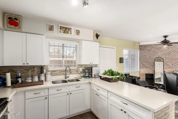 a kitchen with cabinets appliances a sink and a window