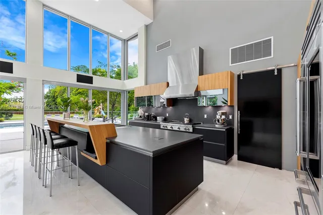 a kitchen with stainless steel appliances kitchen island granite countertop a stove and a sink