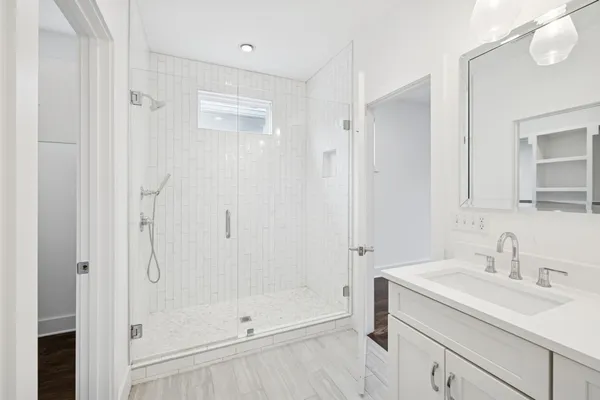 a bathroom with a shower sink and mirror