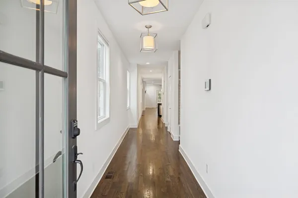 a view of a hallway with wooden floor and staircase