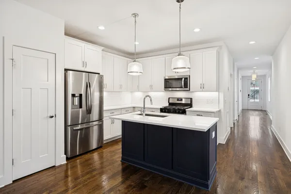 a kitchen with refrigerator cabinets and wooden floor
