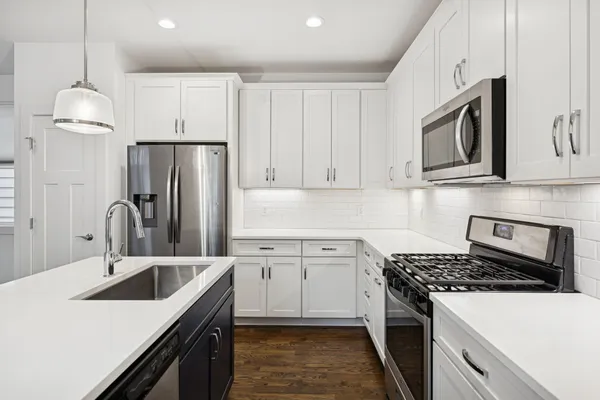 a kitchen with stainless steel appliances granite countertop a sink stove and refrigerator