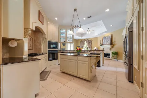 a kitchen with stainless steel appliances granite countertop a refrigerator a sink and a stove