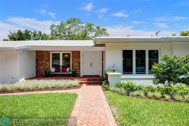 a front view of a house with a yard and potted plants