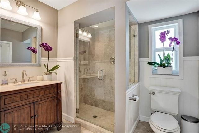 a bathroom with a shower sink vanity mirror and toilet