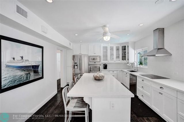 a kitchen that has a lot of cabinets in it with stainless steel appliances