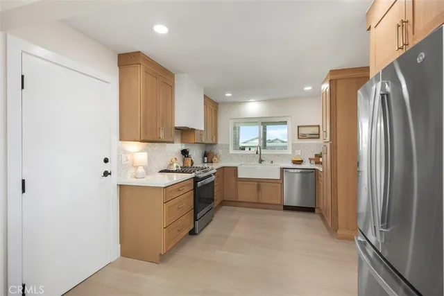 a kitchen with a sink refrigerator and cabinets