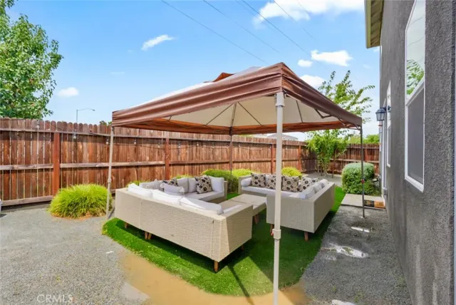 a view of a patio with couches chairs and a small yard