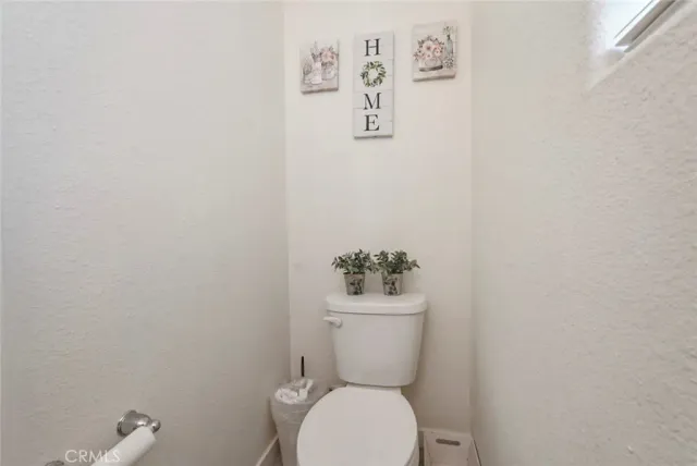 a white toilet sitting next to a white wall