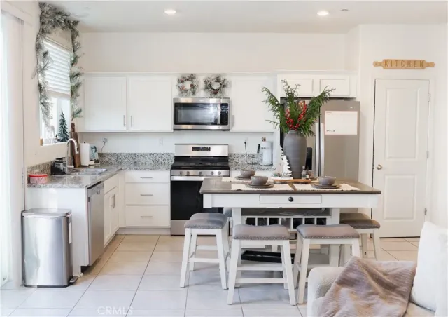 a kitchen with appliances a sink and chairs