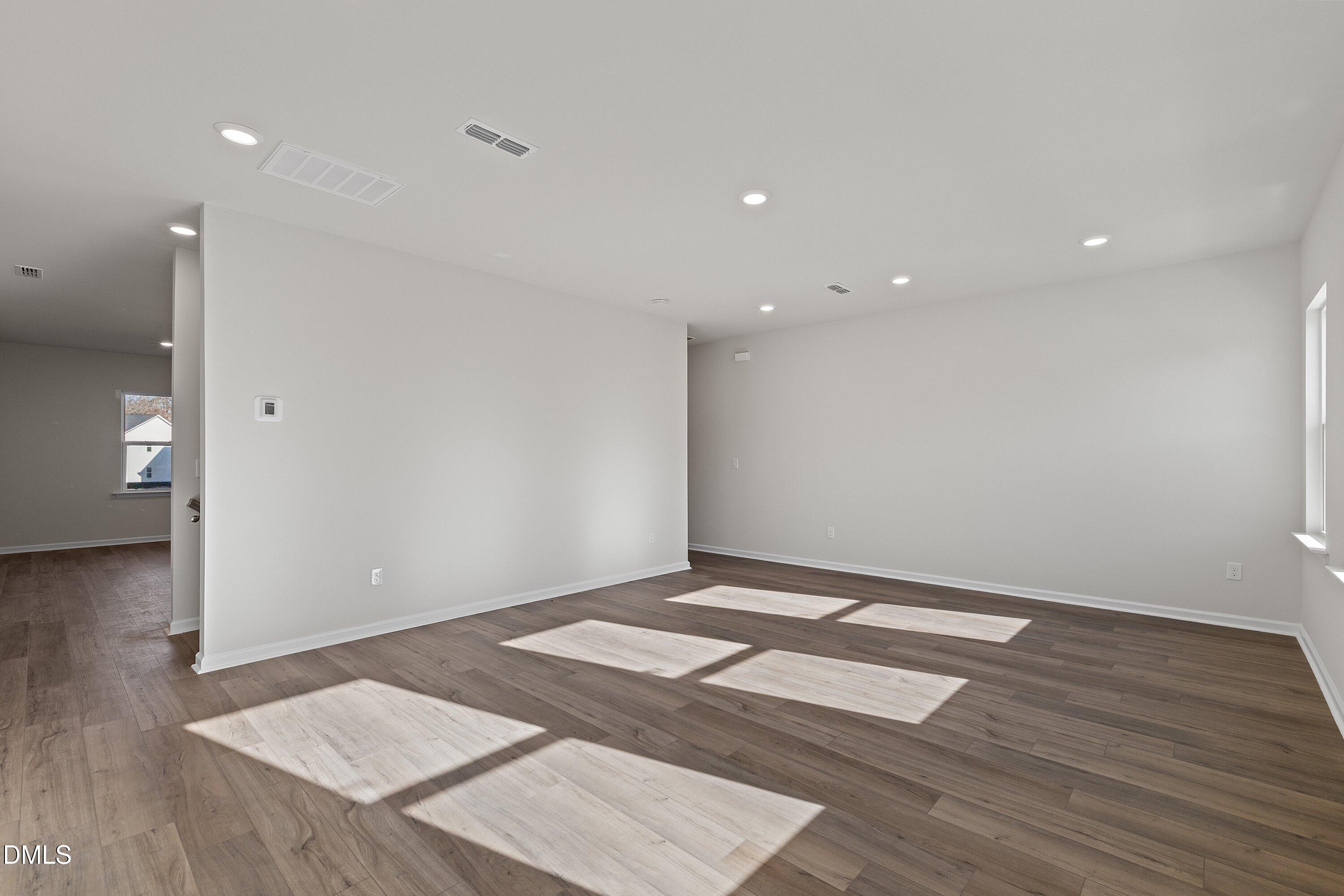 7242 Morris Acres Road Apex, NC 27523 - Photo 16 of 35 an empty room with wooden floor and entrance