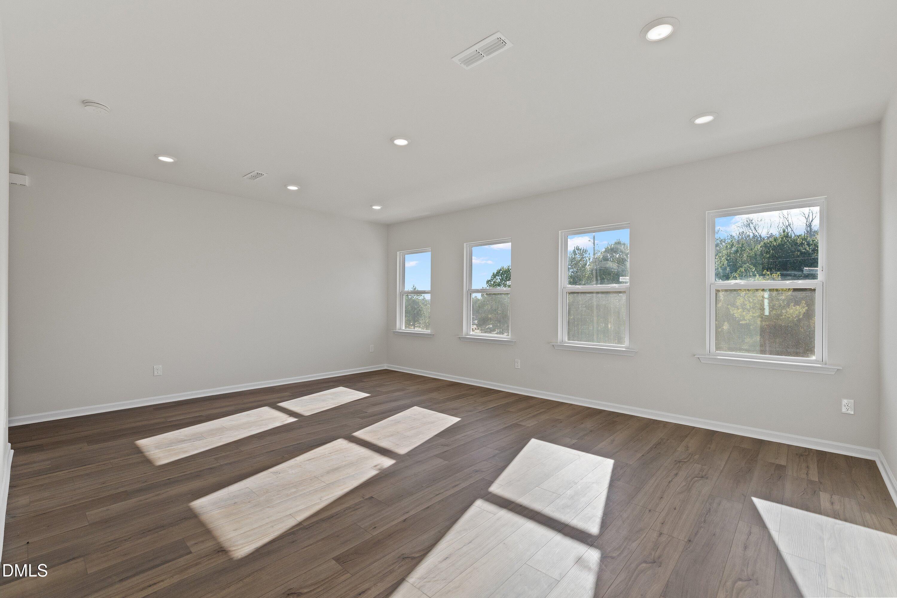 7242 Morris Acres Road Apex, NC 27523 - Photo 18 of 35 a view of an empty room with wooden floor and windows