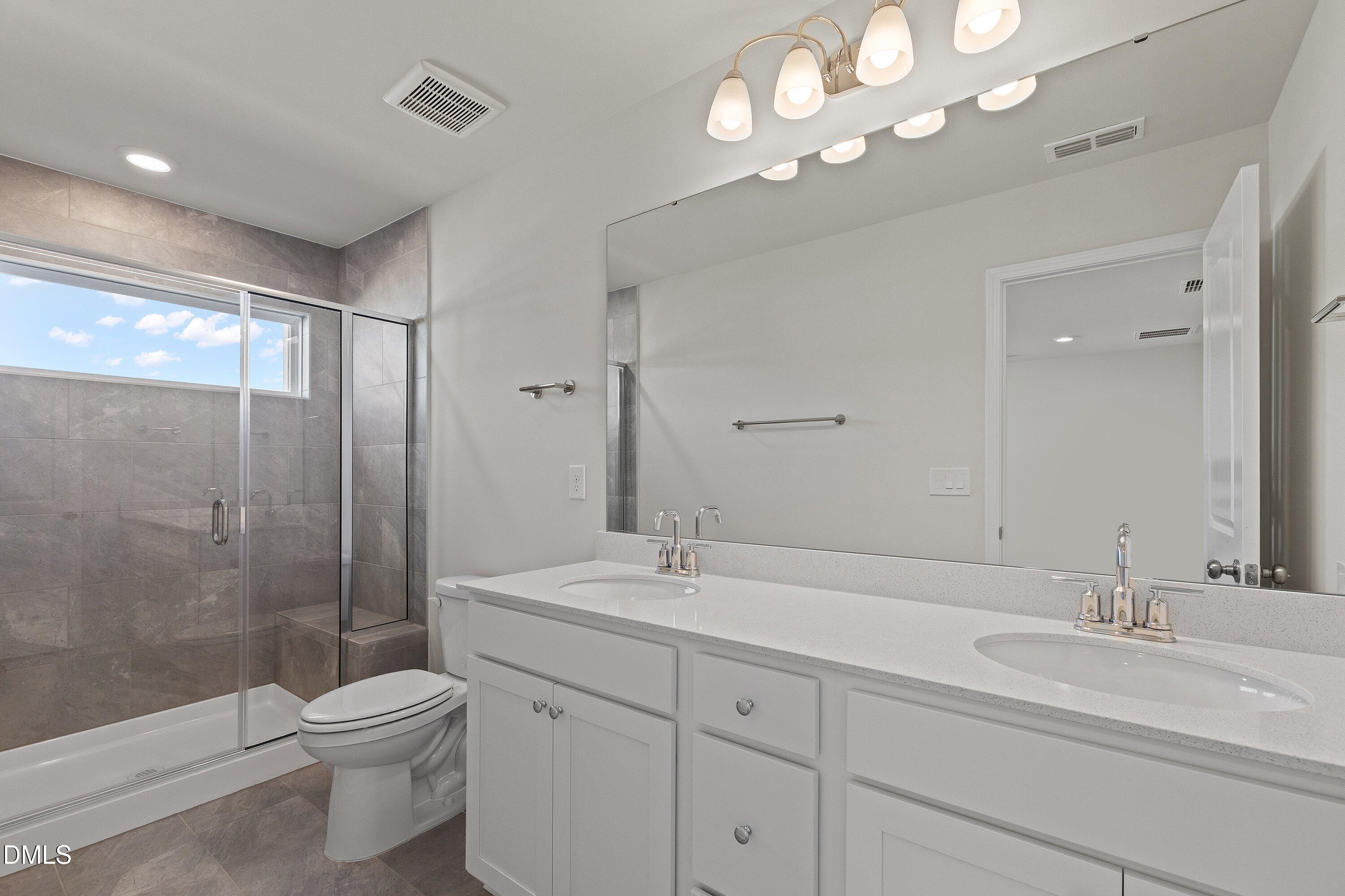 7242 Morris Acres Road Apex, NC 27523 - Photo 24 of 35 a bathroom with a double vanity sink mirror and toilet