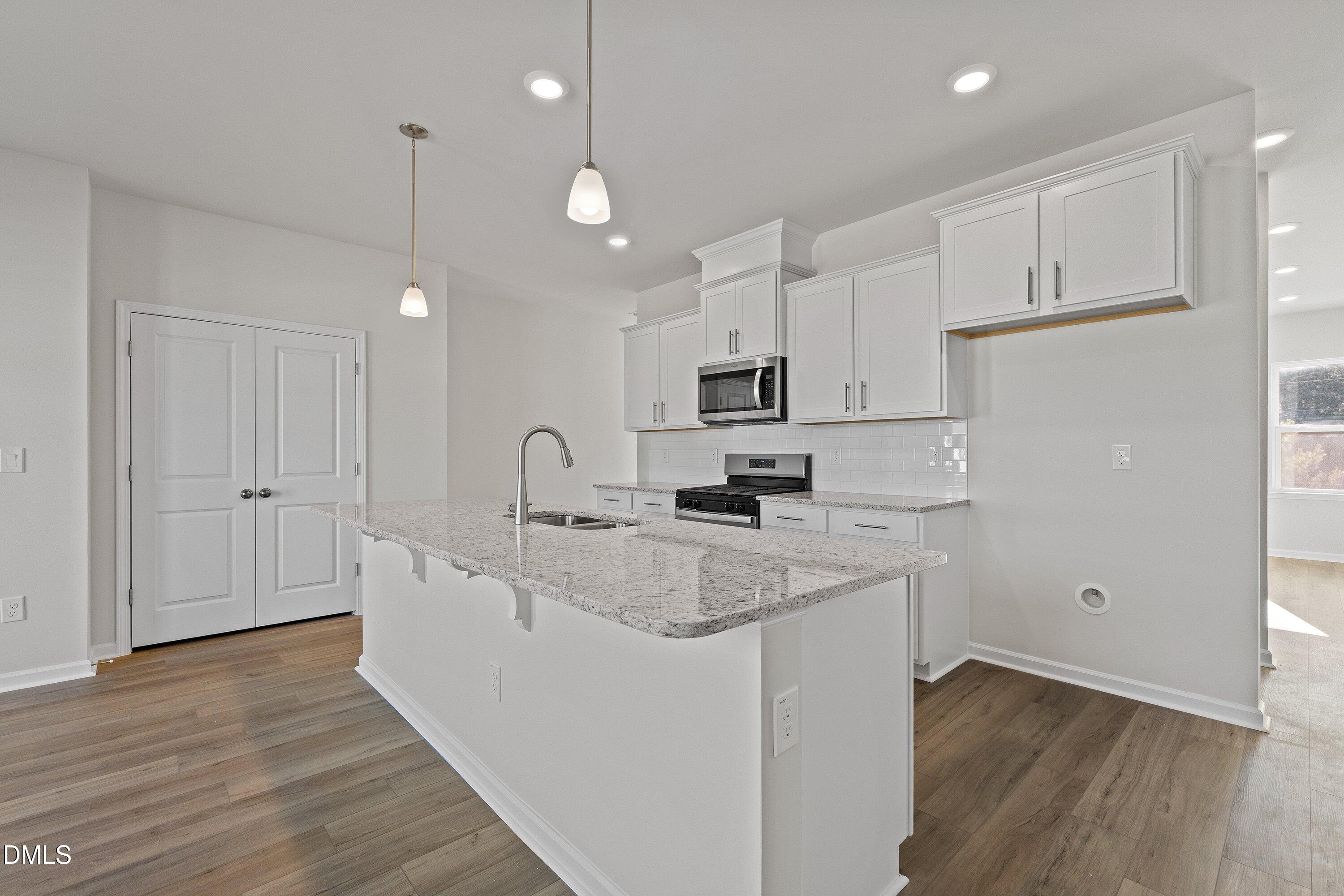 7242 Morris Acres Road Apex, NC 27523 - Photo 6 of 35 a large white kitchen with lots of counter space a sink refrigerator and cabinets