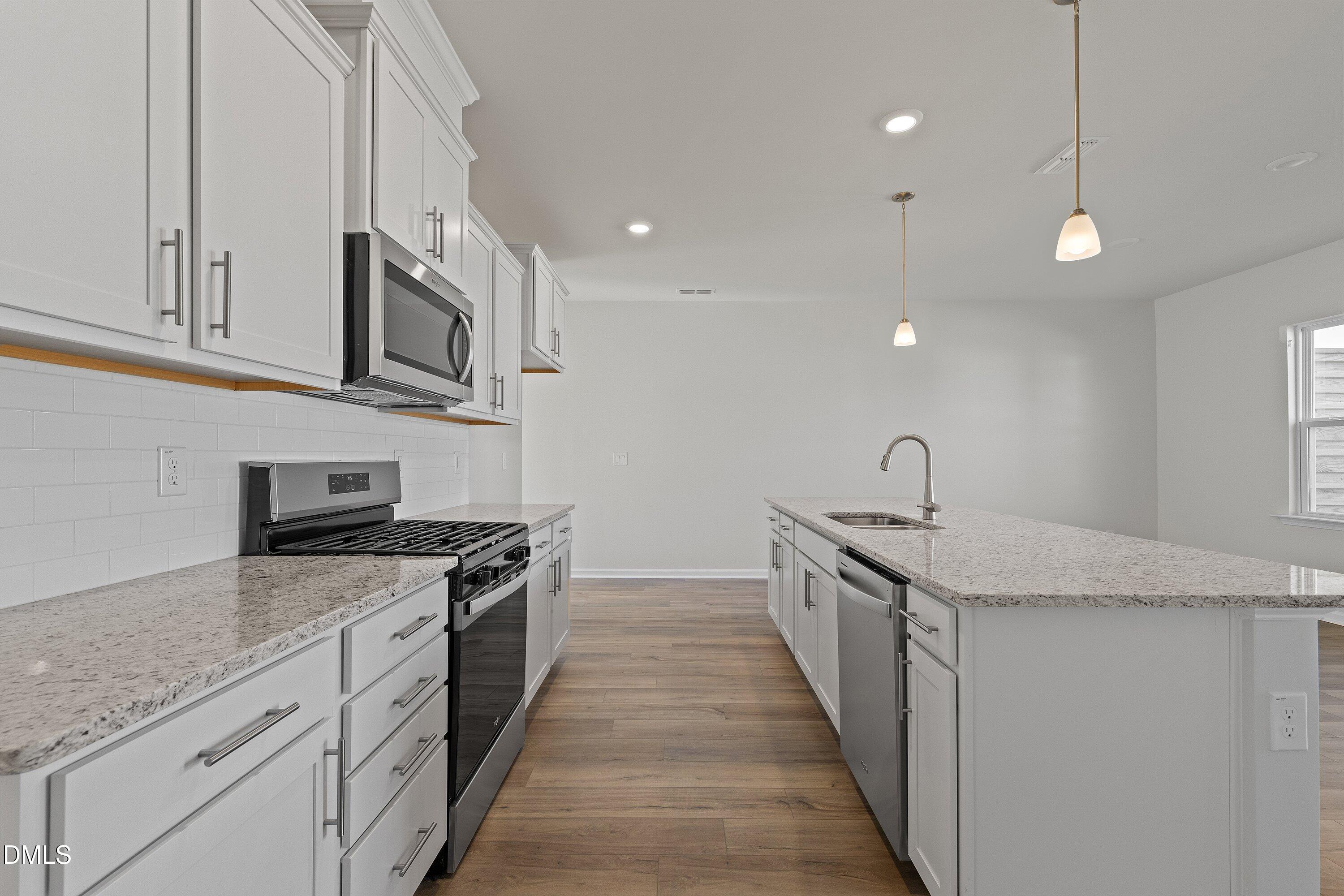 7242 Morris Acres Road Apex, NC 27523 - Photo 7 of 35 a kitchen with stainless steel appliances granite countertop a sink and stove top oven