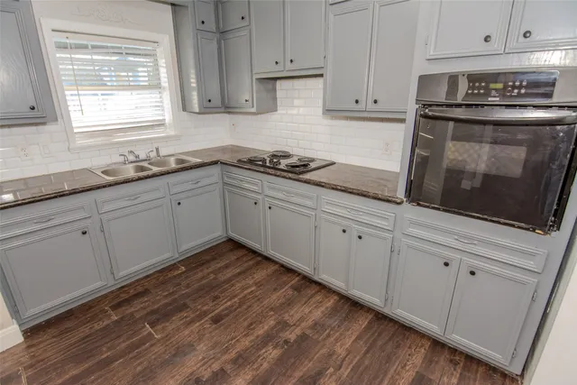 a kitchen with granite countertop white cabinets and white appliances