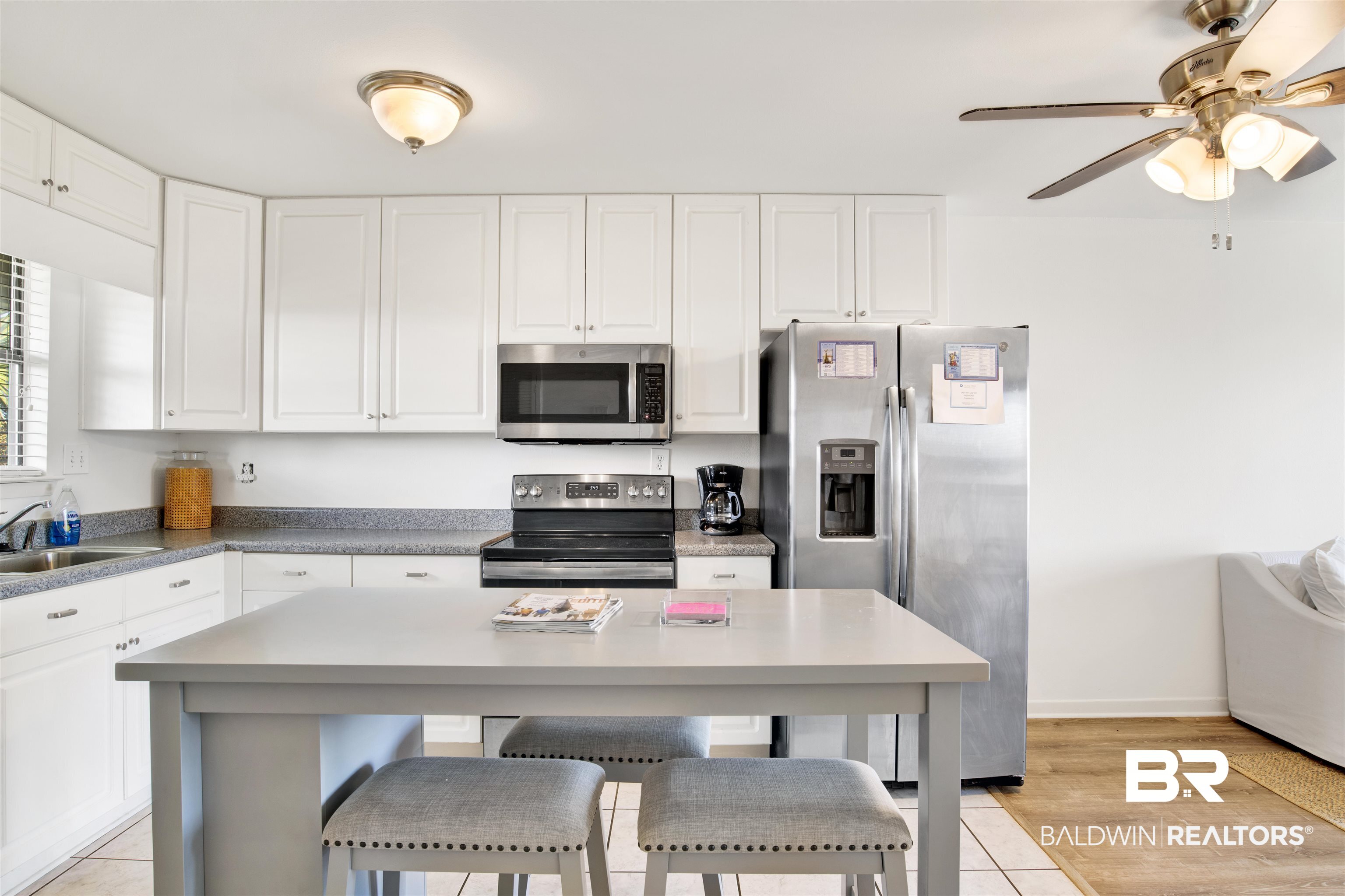 26913 Marina Road, Unit 213 Orange Beach, AL 36561 - Photo 10 of 30 Kitchen featuring appliances with stainless steel finishes, light hardwood / wood-style floors, sink, ceiling fan, and a breakfast bar